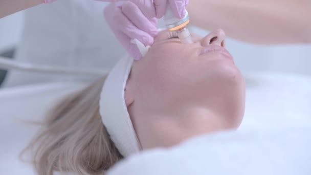 Professionelle Kosmetikerin bei der Gesichtsreinigung mit Wasserstoff — Stockvideo