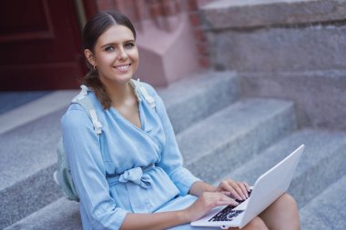 Kampüsteki kız öğrenci dışarıda çalışıyor.