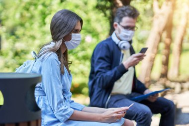 Couple of students in the campus wearing masks due to coronavirus pandemic clipart