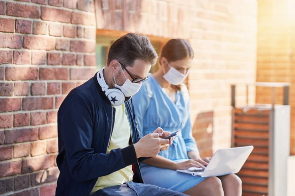 Couple of students in the campus wearing masks due to coronavirus pandemic — Stock Photo, Image