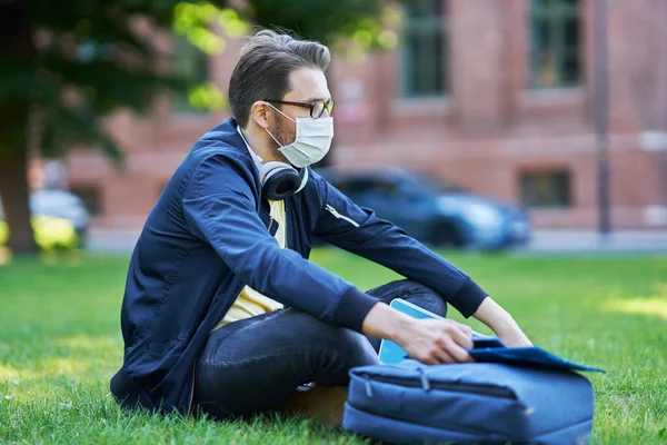 Estudante do sexo masculino no campus usando máscaras devido a pandemia de coronavírus — Fotografia de Stock