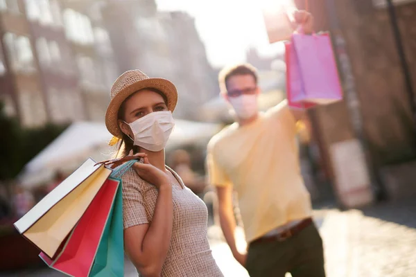 Uma foto de casal com sacos de compras e máscaras protetoras — Fotografia de Stock