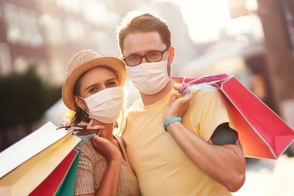 Uma foto de casal com sacos de compras e máscaras protetoras — Fotografia de Stock