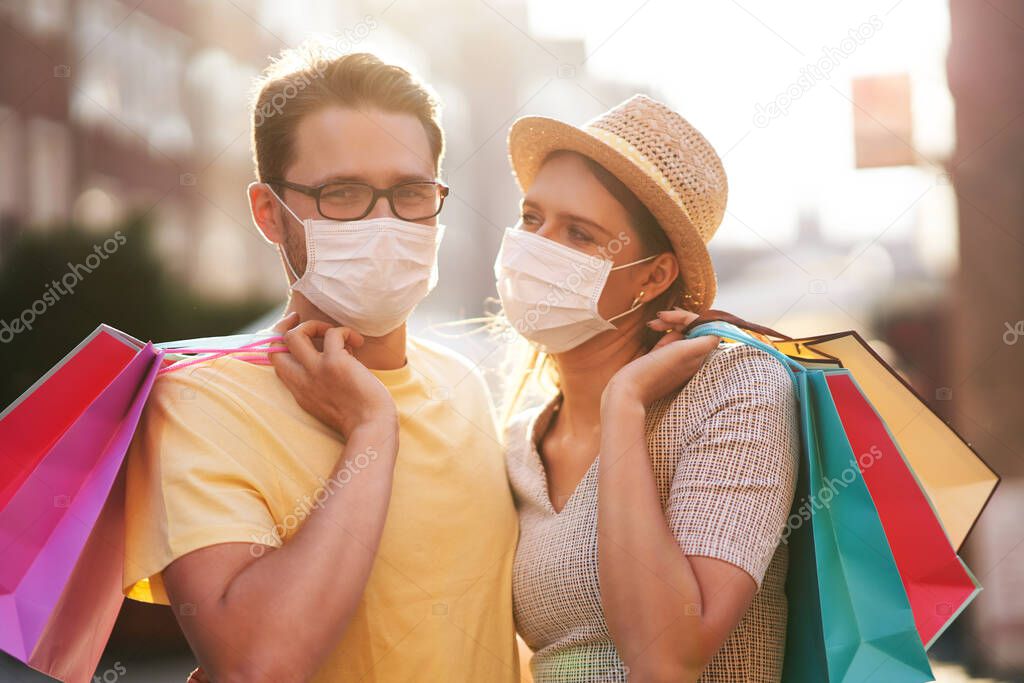A picture of couple with shopping bags and protective masks