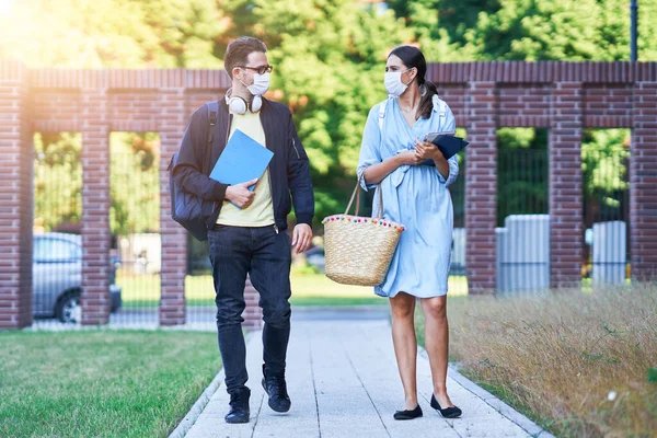 Pár studentů v kampusu nosí masky v důsledku pandemie koronaviru — Stock fotografie