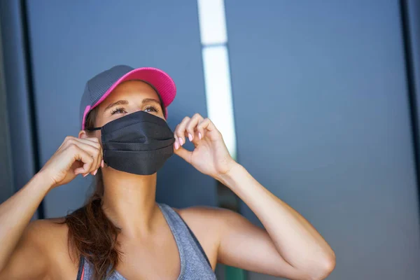 Жіноча бігунка використовує захисну маску під час пандемії коронавірусу — стокове фото