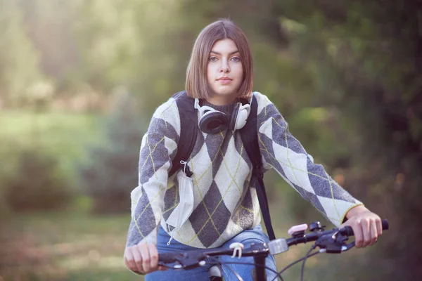 Glücklicher junger positiver Schüler, der mit dem Fahrrad zur Schule fährt — Stockfoto