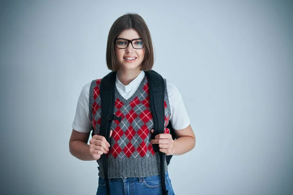 Glad ung positiv student poserar över ljus bakgrund — Stockfoto