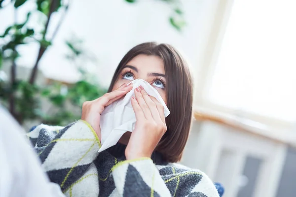 Adolescente estornudando en un pañuelo en la sala de estar — Foto de Stock