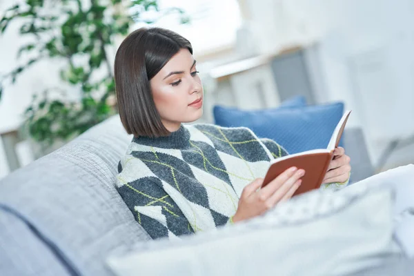 Adolescente lisant un livre à la maison — Photo