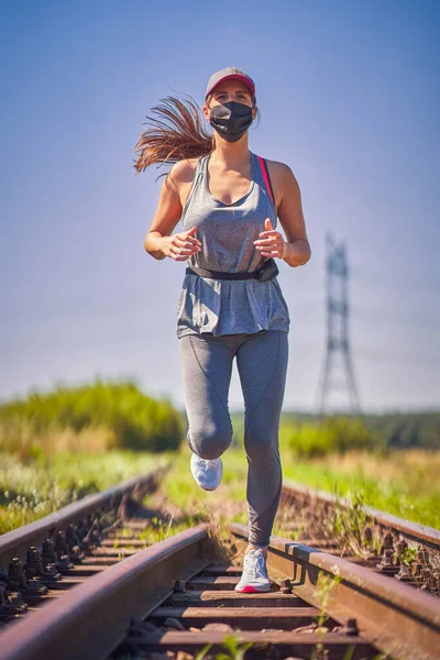 Běžkyně běhá v masce na venkově — Stock fotografie