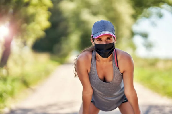 Kırsalda maskeyle koşan kadın koşucu — Stok fotoğraf