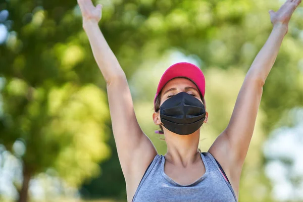 Joggerin läuft maskiert auf dem Land — Stockfoto