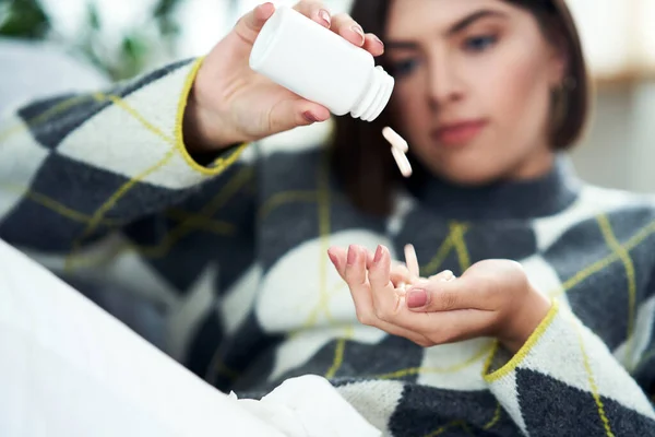 Sjuk tonåring med piller i vardagsrummet — Stockfoto