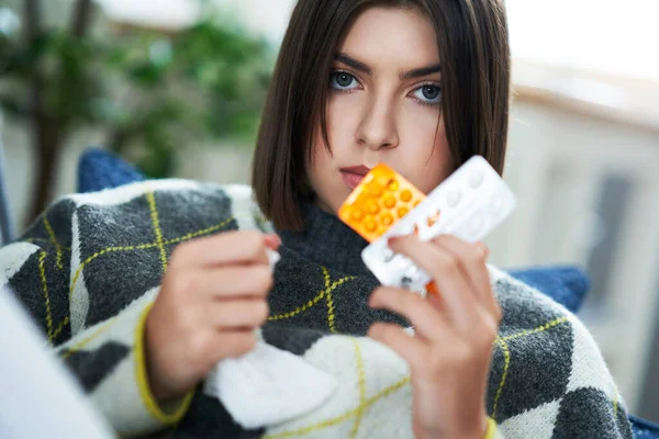 Adolescent malade avec des pilules dans le salon — Photo