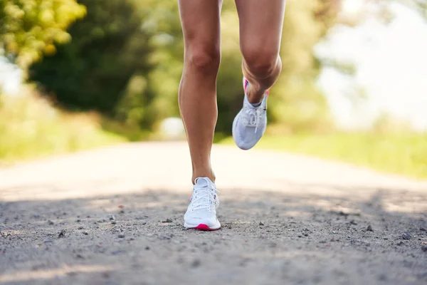 Bawah bagian dari pelari perempuan joging di pedesaan — Stok Foto