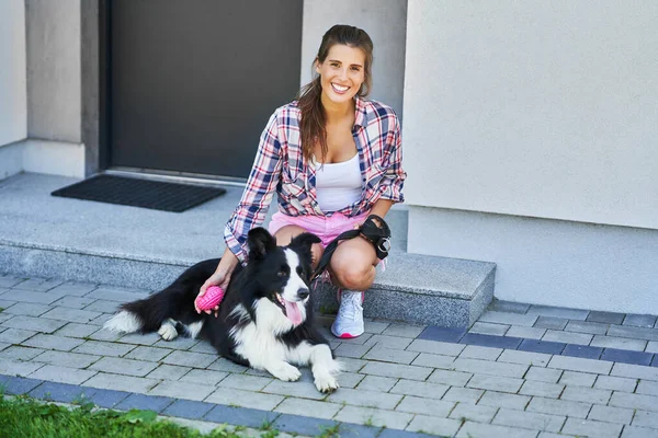 Retrato de mujer feliz paseando a su perro en el ocio — Foto de Stock