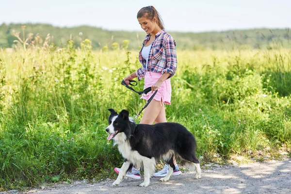 Retrato de mujer feliz paseando a su perro en el ocio — Foto de Stock