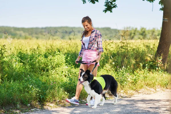 Портрет счастливой женщины, гуляющей с собакой на досуге — стоковое фото