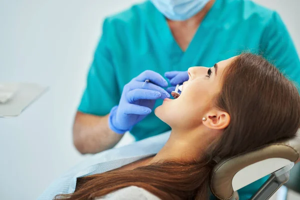 Homem dentista e mulher no consultório odontológico — Fotografia de Stock