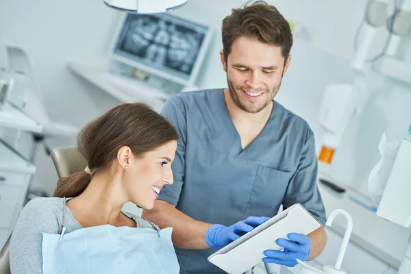 Homem dentista e mulher no consultório odontológico — Fotografia de Stock