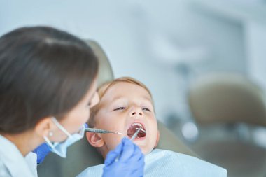 Küçük çocuk ve dişi dişçi muayenehanesinde.