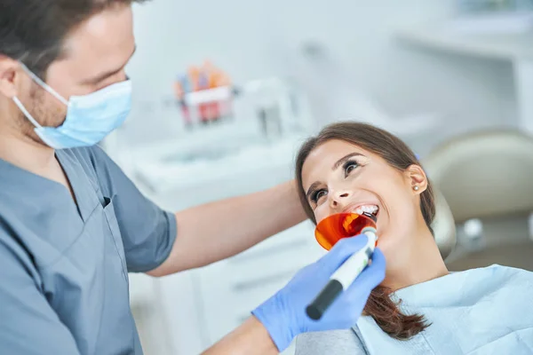 Mannelijke tandarts en vrouw in tandartspraktijk — Stockfoto