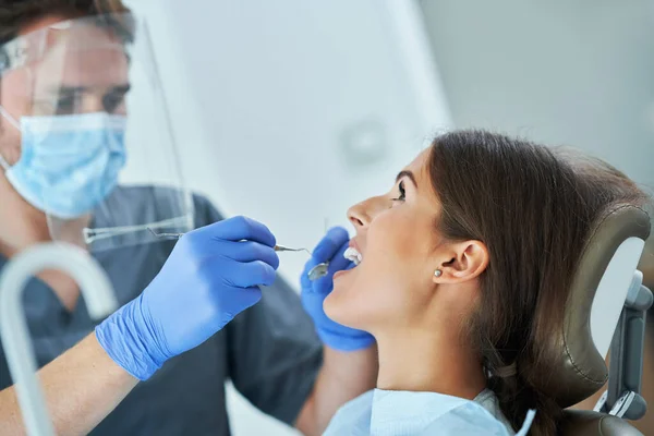 Homem dentista e mulher no consultório odontológico — Fotografia de Stock