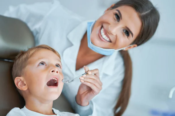 Menino e mulher dentista no consultório de dentistas — Fotografia de Stock