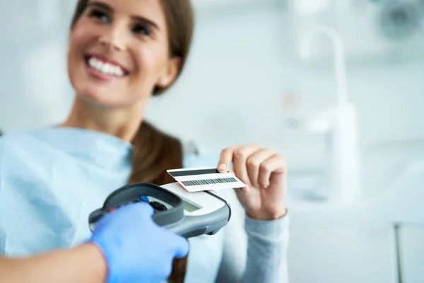 Mulher adulta pagando por visita no consultório odontológico — Fotografia de Stock