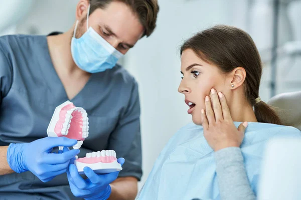 Homem dentista e mulher no consultório odontológico — Fotografia de Stock