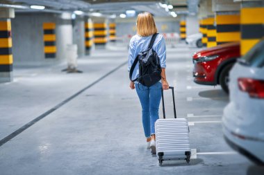 Yetişkin kadın turist yeraltı havaalanı otoparkında.