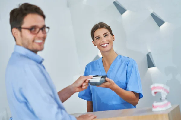 Paciente pagando por visita dental en clínica — Foto de Stock