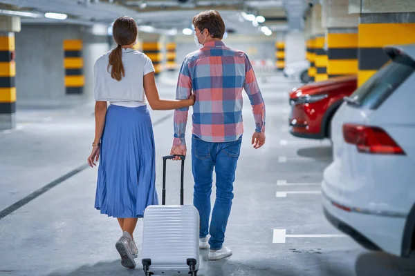 Un par de turistas en el estacionamiento subterráneo del aeropuerto — Foto de Stock