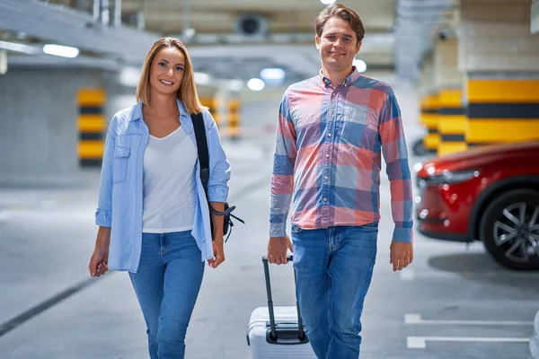 Un par de turistas en el estacionamiento subterráneo del aeropuerto — Foto de Stock