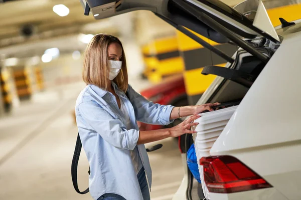 Donna adulta turista indossa maschera nel parcheggio sotterraneo dell'aeroporto — Foto Stock