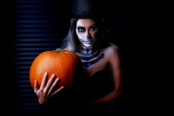 Spooky portret van vrouw in halloween gotische make-up houden pompoen — Stockfoto