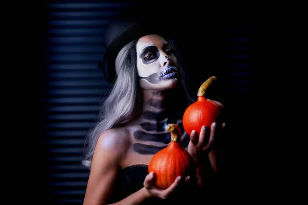 Gruseliges Porträt einer Frau in Halloween-Gotik-Make-up mit Kürbis — Stockfoto