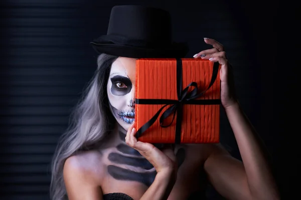 Gruseliges Porträt einer Frau in Halloween-Gotik-Make-up mit Geschenk — Stockfoto