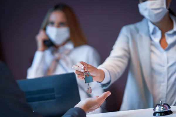 Empresário mascarado na recepção de um hotel check-in — Fotografia de Stock