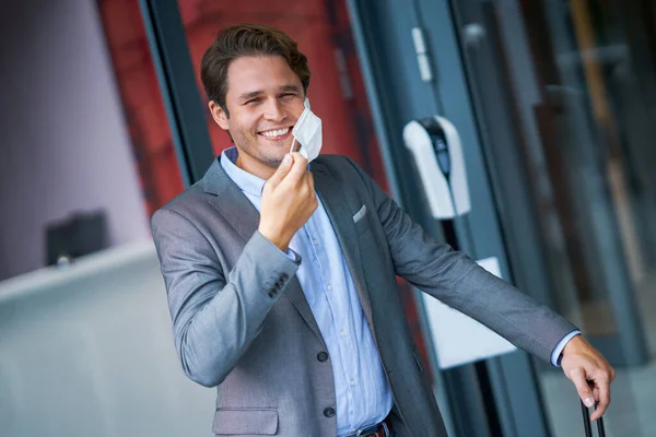 Adult businessman leaving hotel in mask due to covid-19 restrictions — Stock Photo, Image