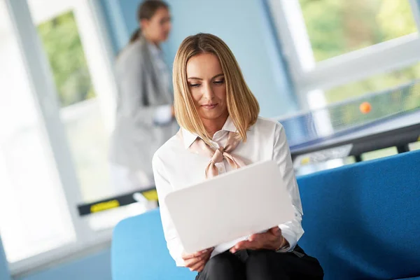 Adult businesswoman using computer in playroom relax zone — Stock Photo, Image