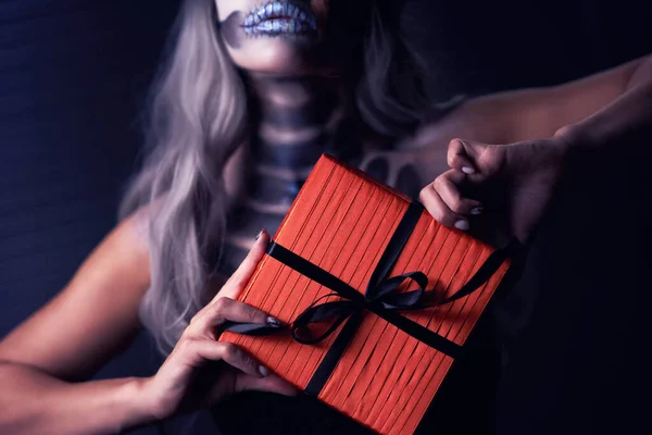 Spooky portrait of woman in halloween gotic makeup holding present — Stock Photo, Image