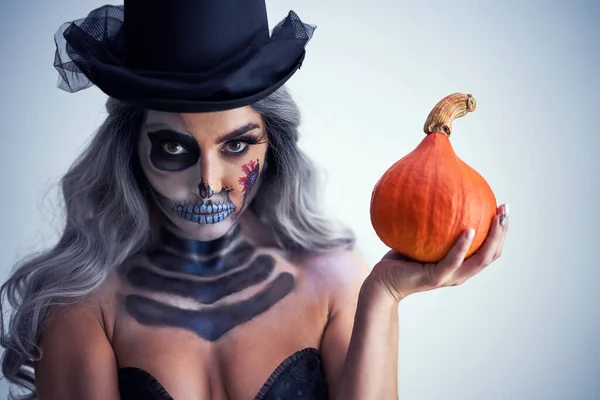 Spooky portrait of woman in halloween gotic makeup holding pumpkin — Stock Photo, Image