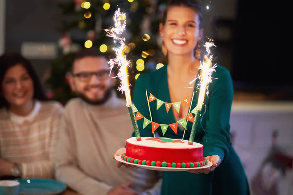 Grupa przyjaciół świętuje Boże Narodzenie w domu z fantazyjnym tortem — Zdjęcie stockowe