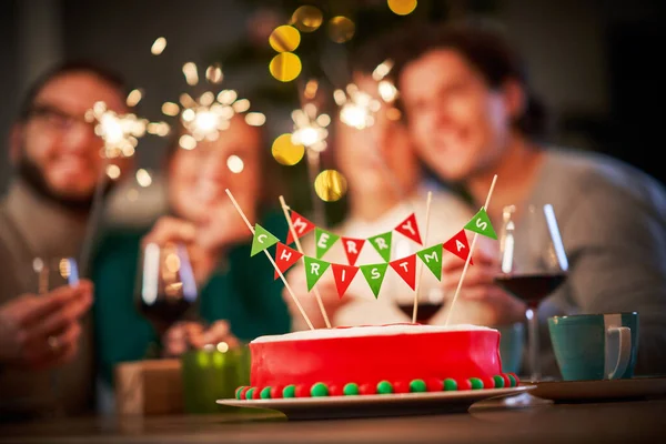 Grupo de amigos celebrando la Navidad en casa con un pastel de lujo —  Fotos de Stock