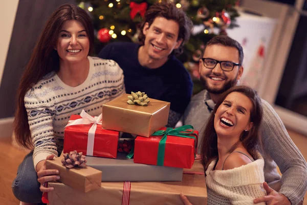 Gruppo di amici con regali per festeggiare il Natale a casa — Foto Stock