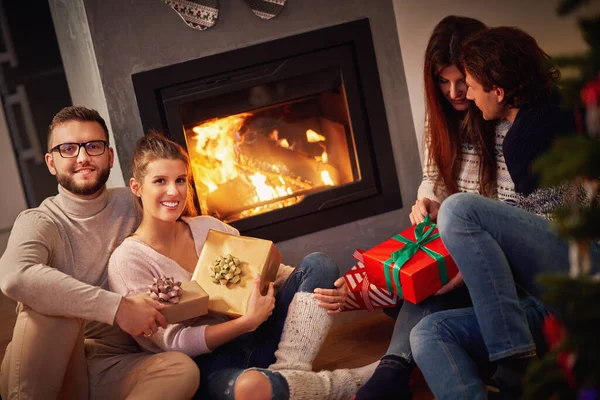 Grupo de amigos con regalos celebrando la Navidad en casa — Foto de Stock