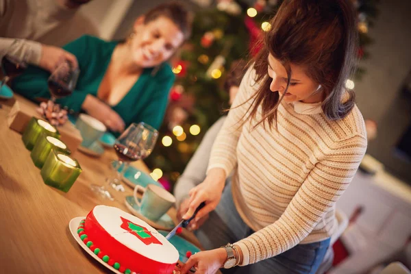 Grupo de amigos celebrando la Navidad en casa con un pastel de lujo —  Fotos de Stock