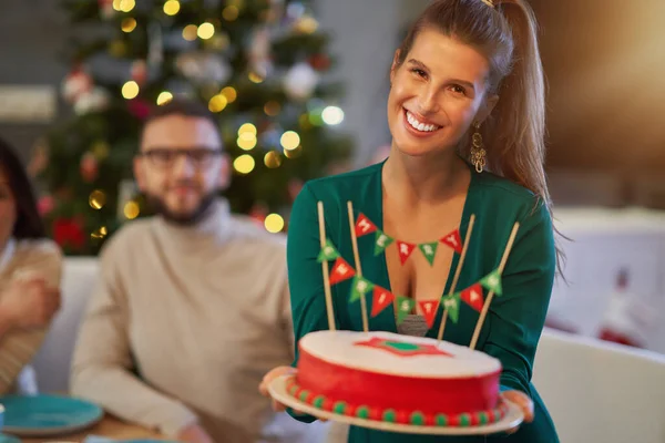 Группа друзей, празднующих Рождество дома с модным тортом — стоковое фото